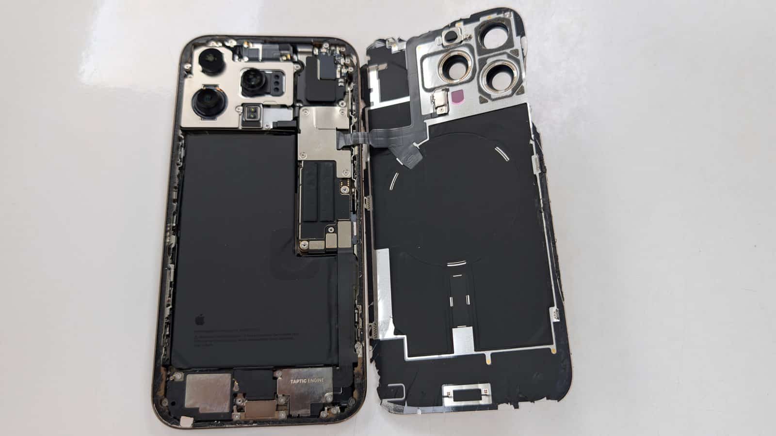 Opened iPhone showing its battery, cameras and internal components during repair at iTech Norwich